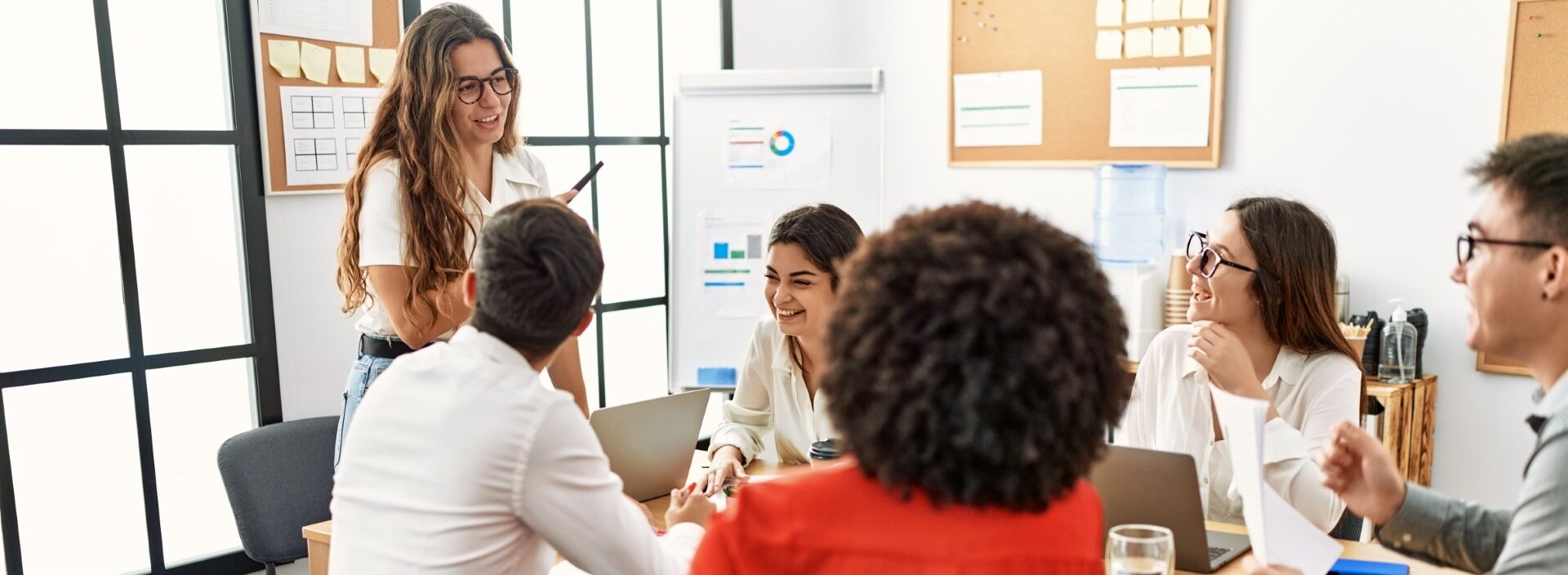 Un groupe de personnes assises autour d'une table dans un bureau, discutant et collaborant sur un projet.