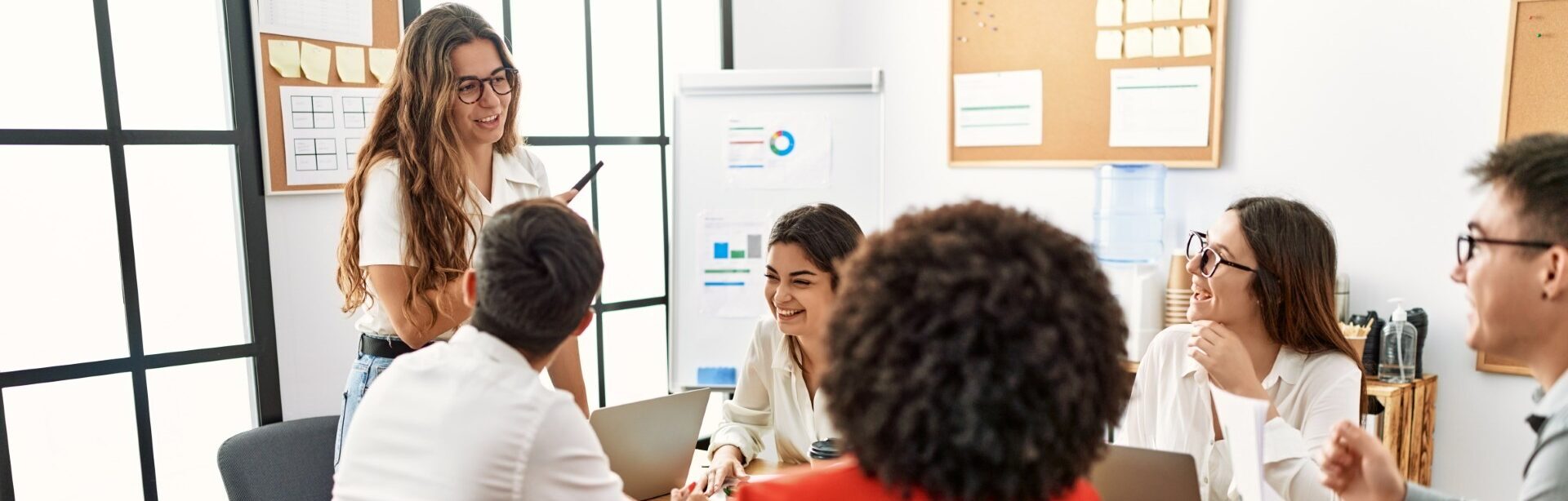 Un groupe de personnes assises autour d'une table dans un bureau, discutant et collaborant sur un projet.
