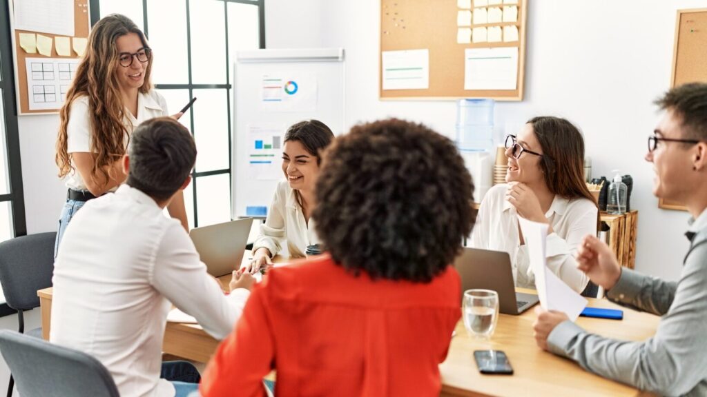 Un groupe de personnes assises autour d'une table dans un bureau, discutant et collaborant sur un projet.